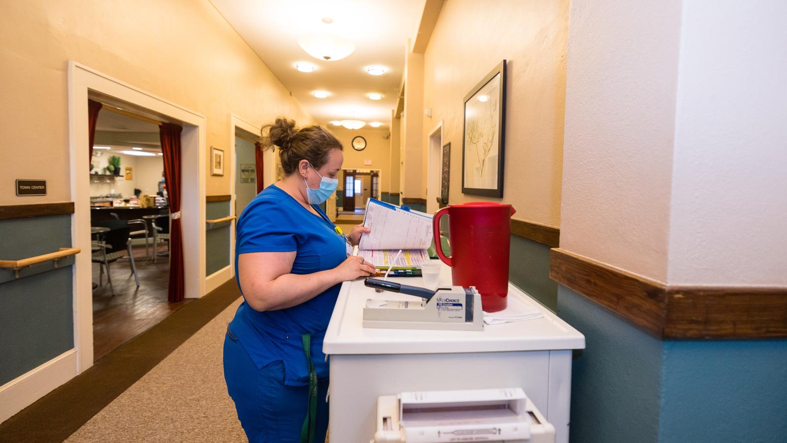 Nurse at station, monitoring supplies. 